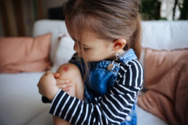 Mãe e filho em ambiente doméstico seguro com produtos de segurança infantil visíveis